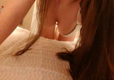 hot curvy teen bent forward over bed while biting her lips making sexy selfie