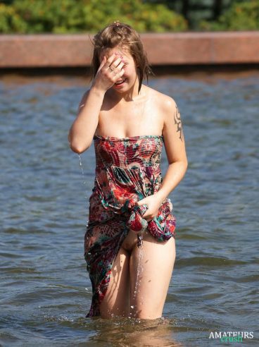 amateur all wet in a big fountain and wrenching her bottom dress causing a accidental upskirt