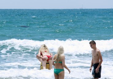 Girl in wet panties having a wardrobe malfuntion and showing her butthole while boyfriend carrying her at sea on the beach