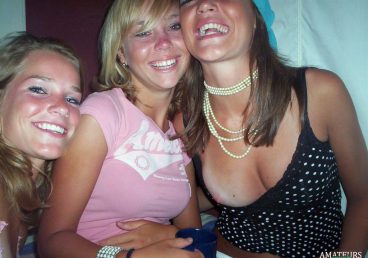 drunk collegegirls taking a picture together while one of them is having a public nip slip