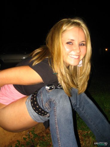 beautiful blonde girl peeing outdoor with her pants down
