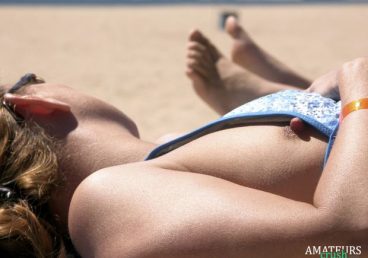 close up of a public nip slip at the beach while tanning