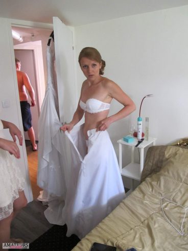 Big wedding day of sexy wife putting on her weddingdress