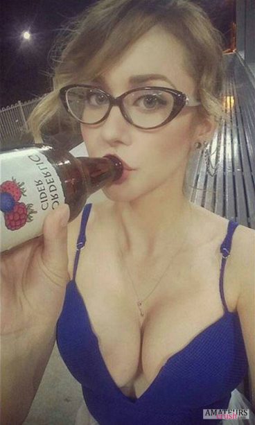 Busty girl wearing glasses while drinking cider selfie