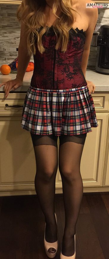 Sexy petite girlfriend leaning against counter with her sexy mini skirt and leggings in high heels