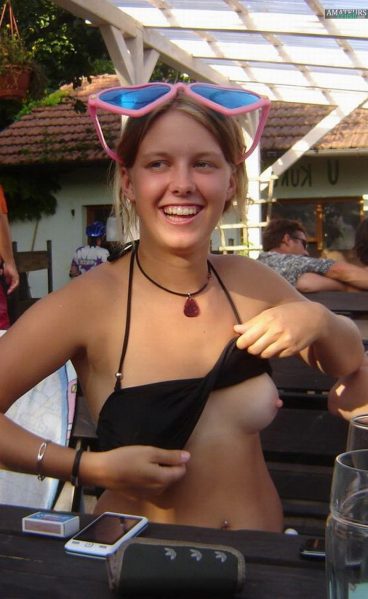 Cute girl with hard nipples showing her boobs at the bench with lots of people surrounding her